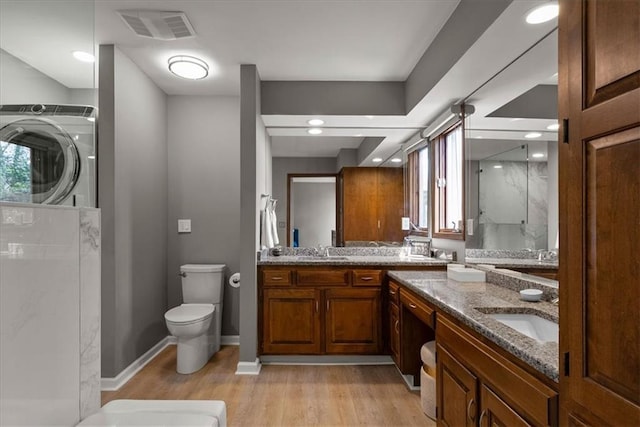 full bath featuring a wealth of natural light, wood finished floors, visible vents, and a sink