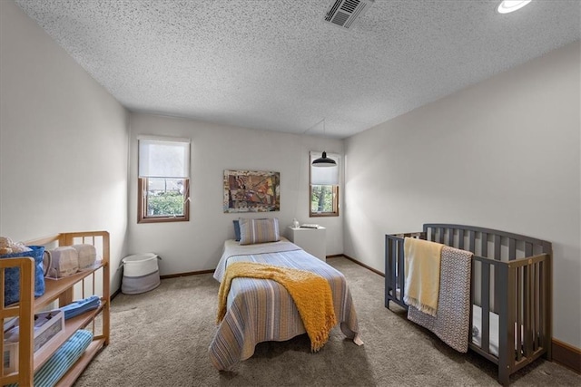 bedroom with baseboards, visible vents, a textured ceiling, and carpet flooring