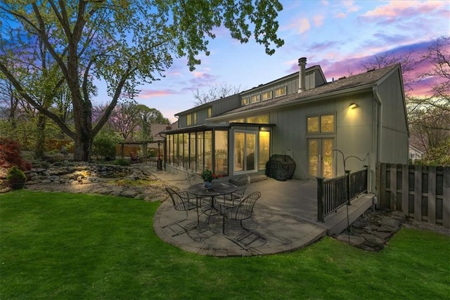 back of house featuring a chimney, a patio area, a lawn, and fence private yard