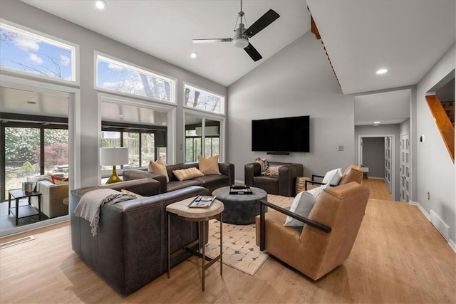 living area featuring plenty of natural light, light wood-style flooring, high vaulted ceiling, and a ceiling fan