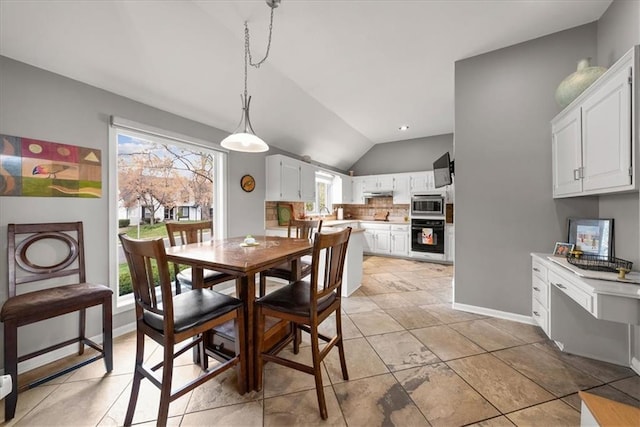 dining area with vaulted ceiling and baseboards