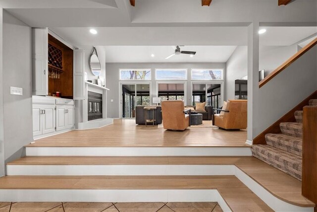 interior space with stairway, ceiling fan, a glass covered fireplace, and recessed lighting