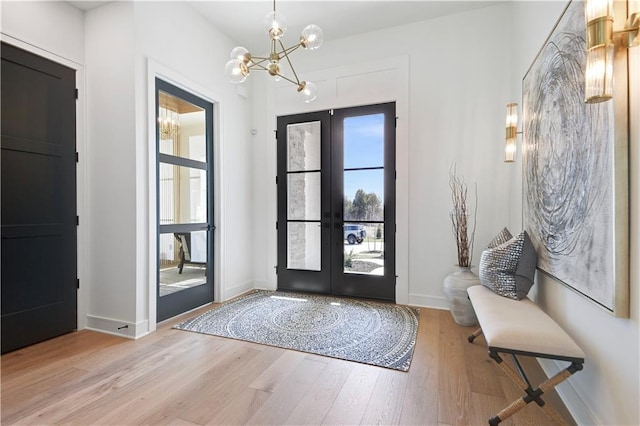 entryway with french doors, baseboards, an inviting chandelier, and wood finished floors