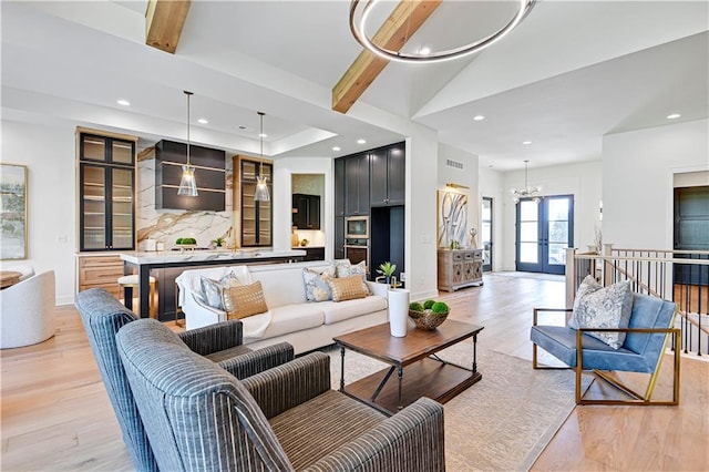 living room featuring light wood-style flooring, vaulted ceiling with beams, an inviting chandelier, and recessed lighting