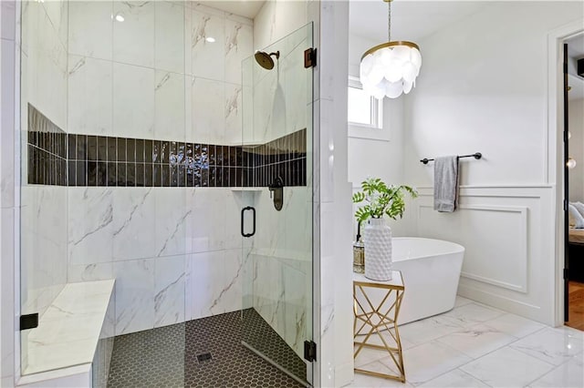 full bathroom featuring a freestanding bath, a notable chandelier, ensuite bath, a marble finish shower, and marble finish floor