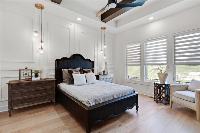 bedroom with light wood-style flooring, a decorative wall, and recessed lighting