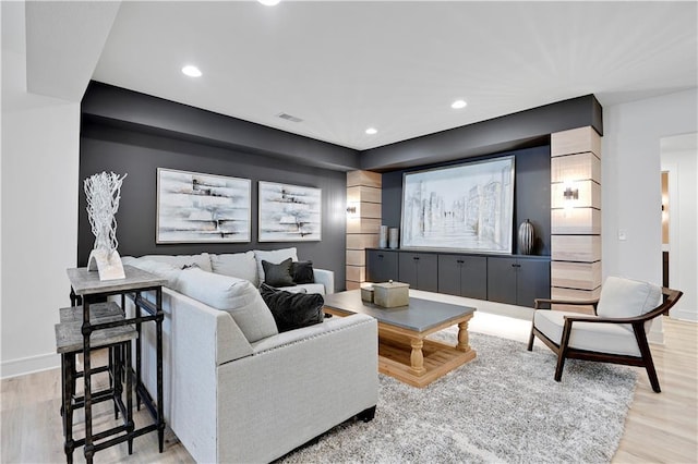 living room with recessed lighting, visible vents, baseboards, and light wood-style flooring