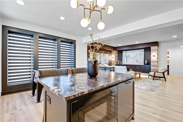 kitchen with a chandelier, light wood-style floors, black microwave, recessed lighting, and pendant lighting