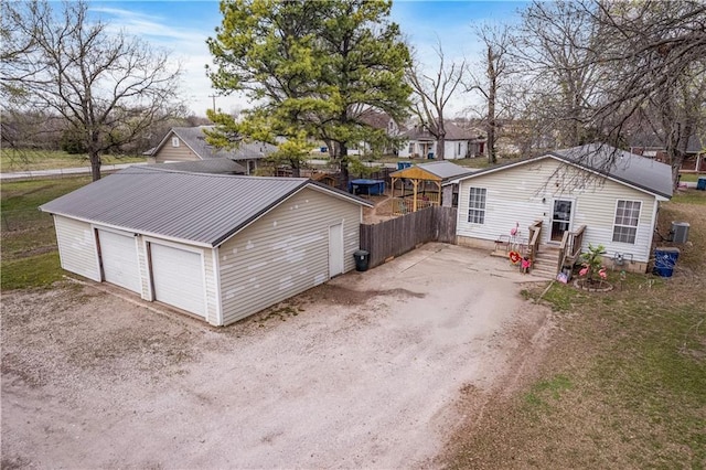 exterior space with a detached garage and fence