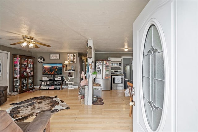 interior space featuring a textured ceiling, ceiling fan, and wood finished floors