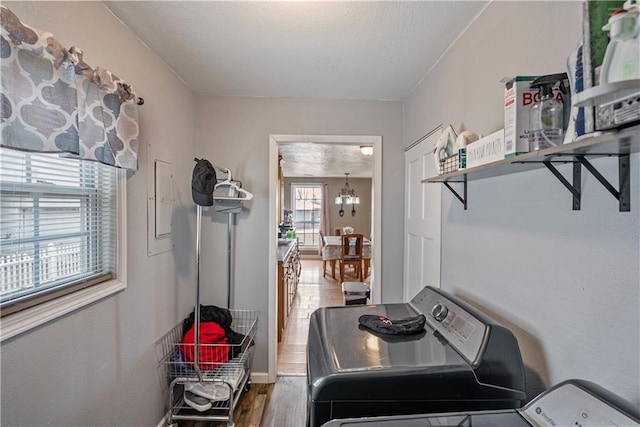 washroom featuring independent washer and dryer, a chandelier, a textured ceiling, laundry area, and wood finished floors