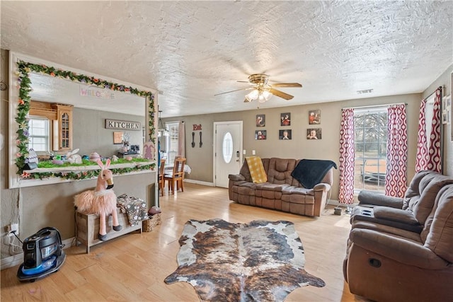 living room with visible vents, wood finished floors, ceiling fan, and a healthy amount of sunlight