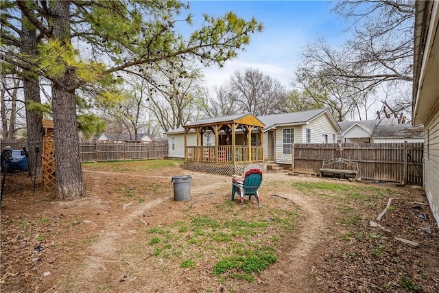 back of house with a fenced backyard and a wooden deck