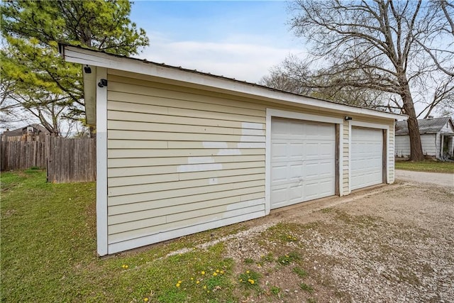 detached garage featuring fence