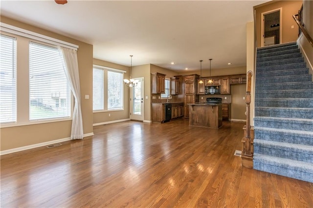 17281 S Kimble St, Olathe, KS 66062 - unfurnished living room with a chandelier, stairway, dark wood-style floors, and recessed lighting