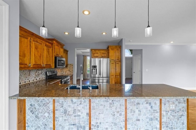 kitchen featuring a sink, brown cabinetry, stainless steel appliances, and dark stone countertops