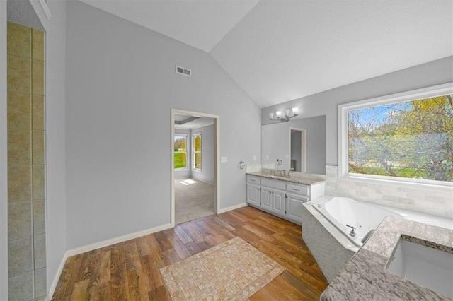 full bathroom with a bath, visible vents, wood finished floors, vanity, and high vaulted ceiling