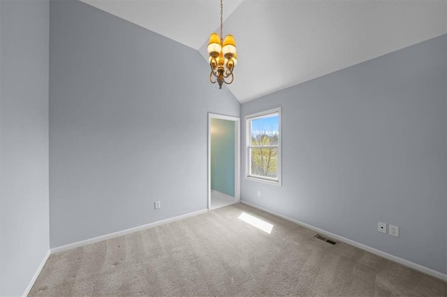spare room with visible vents, an inviting chandelier, baseboards, carpet flooring, and vaulted ceiling