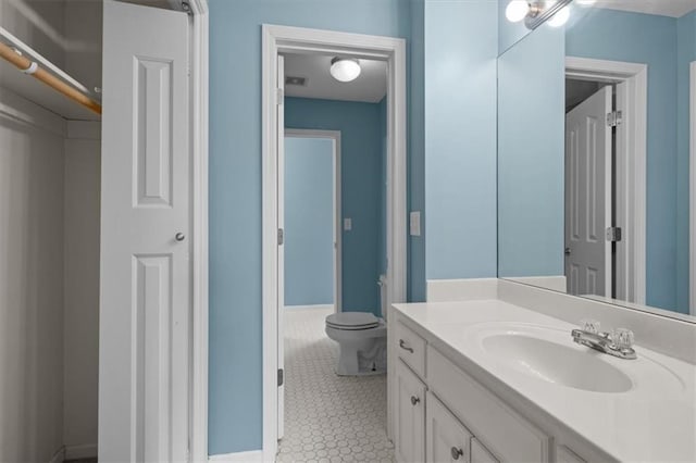 bathroom with vanity, visible vents, toilet, baseboards, and tile patterned floors