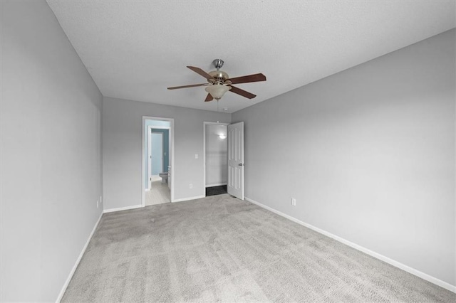 unfurnished bedroom featuring carpet flooring, a ceiling fan, baseboards, and ensuite bathroom