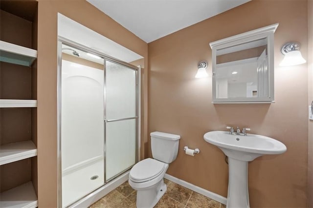 full bathroom featuring baseboards, a stall shower, and toilet