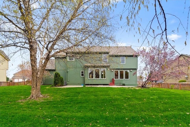 rear view of property featuring a lawn, a patio, and fence private yard