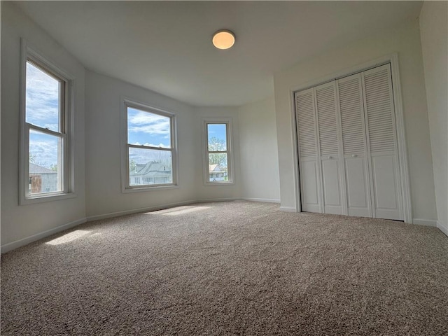unfurnished bedroom with baseboards, a closet, and carpet