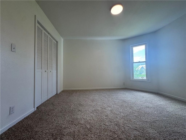 unfurnished bedroom featuring carpet, a closet, and baseboards