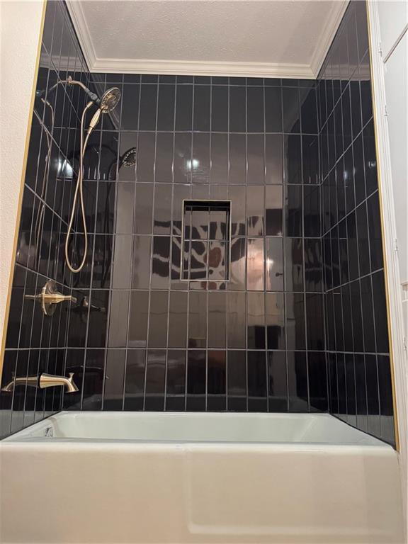 bathroom with crown molding and  shower combination