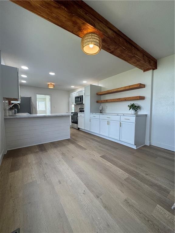 kitchen featuring white cabinets, stainless steel microwave, light wood-type flooring, open shelves, and range with electric stovetop