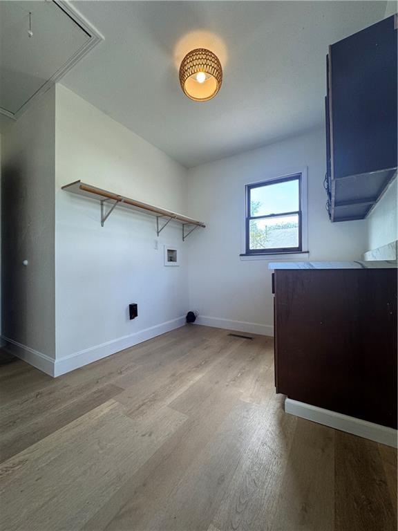 laundry area featuring attic access, baseboards, light wood-style floors, and laundry area