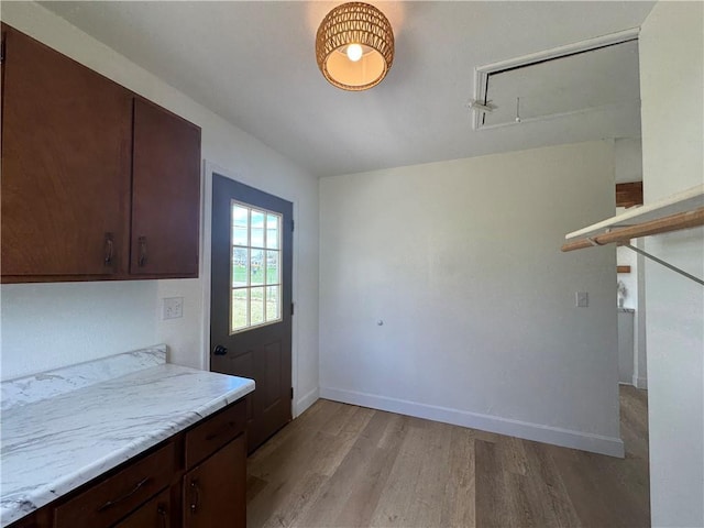 interior space featuring light wood-type flooring and baseboards