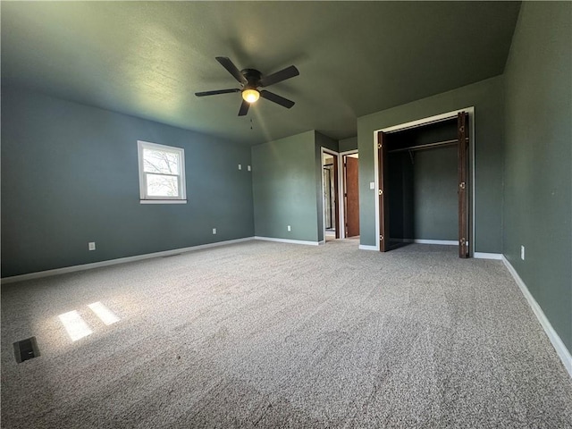 unfurnished bedroom with ceiling fan, carpet floors, and baseboards