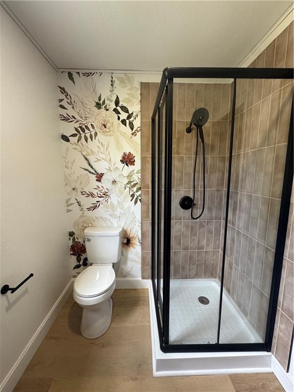 full bathroom with baseboards, toilet, a stall shower, and wood finished floors