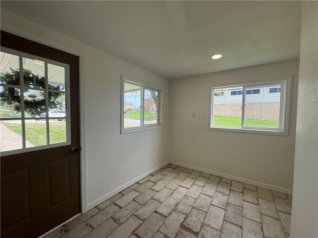 interior space featuring recessed lighting, brick floor, and baseboards