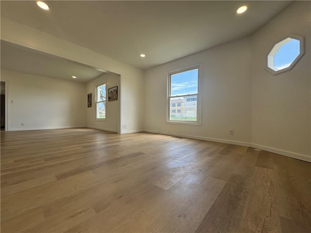 unfurnished room featuring baseboards, wood finished floors, and recessed lighting