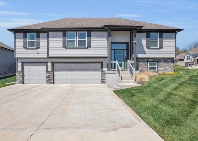 900 NW Lindenwood Dr, Grain Valley, MO 64029 - raised ranch with an attached garage, a front yard, concrete driveway, stone siding, and roof with shingles