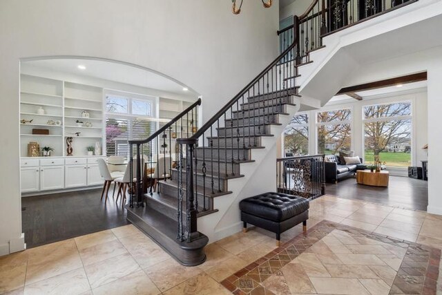 stairs with a high ceiling, baseboards, and tile patterned flooring