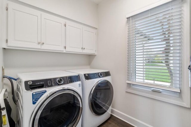 laundry room with baseboards, washer and clothes dryer, cabinet space, and dark wood-style flooring