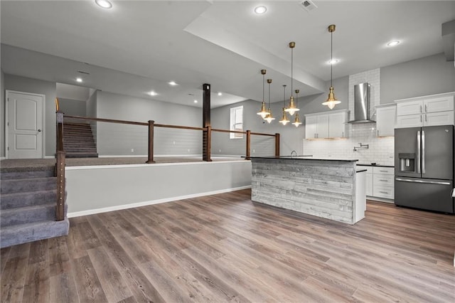 7295 NW Forest Lakes Dr, Parkville, MO 64152 - kitchen with stainless steel fridge, wall chimney range hood, open floor plan, recessed lighting, and tasteful backsplash