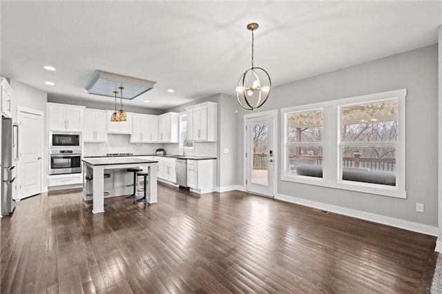 7295 NW Forest Lakes Dr, Parkville, MO 64152 - kitchen featuring stainless steel appliances, a chandelier, a breakfast bar, white cabinets, and a kitchen island