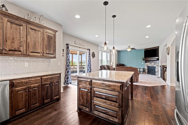 kitchen featuring backsplash, a ceiling fan, a fireplace, and dark wood-type flooring