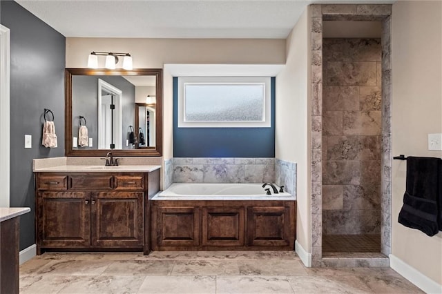 bathroom featuring baseboards, tiled shower, a garden tub, and vanity