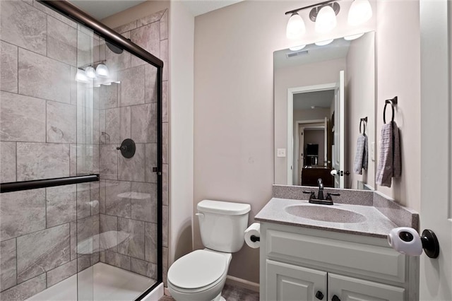 full bathroom featuring vanity, a stall shower, toilet, and visible vents