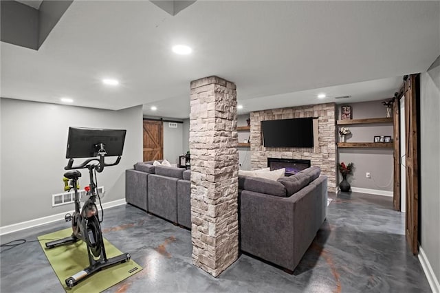 living area featuring baseboards, concrete flooring, and a barn door