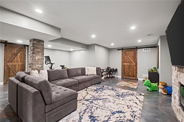living area featuring visible vents, a barn door, concrete flooring, and recessed lighting