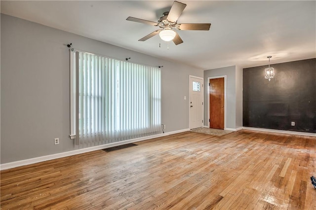 10408 E 28th Ter S, Independence, MO 64052 - unfurnished living room featuring a ceiling fan, wood finished floors, and baseboards