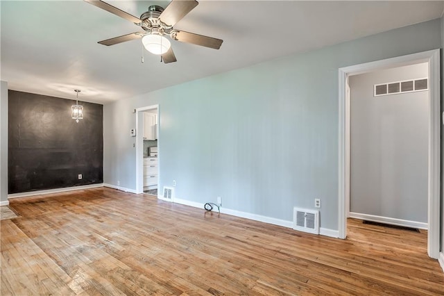 10408 E 28th Ter S, Independence, MO 64052 - empty room featuring wood finished floors, a ceiling fan, baseboards, and a chandelier