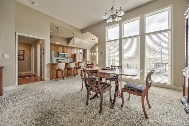 12207 England St, Overland Park, KS 66213 - dining space featuring light carpet, a notable chandelier, and baseboards