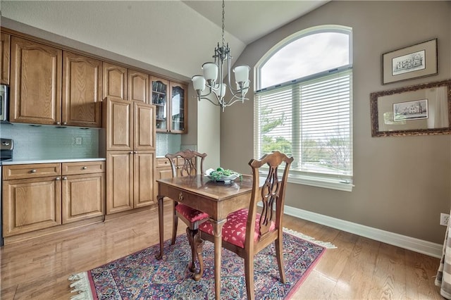 12207 England St, Overland Park, KS 66213 - dining space featuring baseboards, a notable chandelier, light wood-style floors, and lofted ceiling